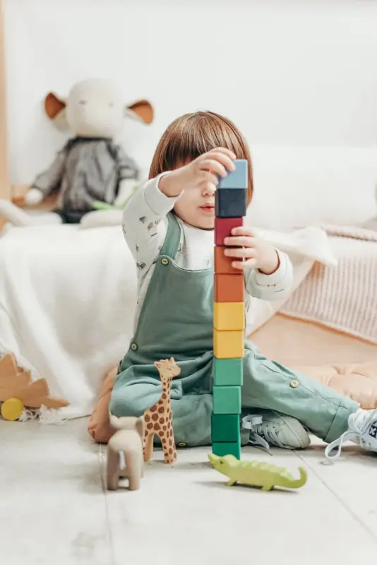 Child in White Long-sleeve Top and Dungaree Trousers Playing With Lego Blocks- cottonbro