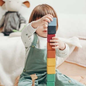 Child in White Long-sleeve Top and Dungaree Trousers Playing With Lego Blocks- cottonbro